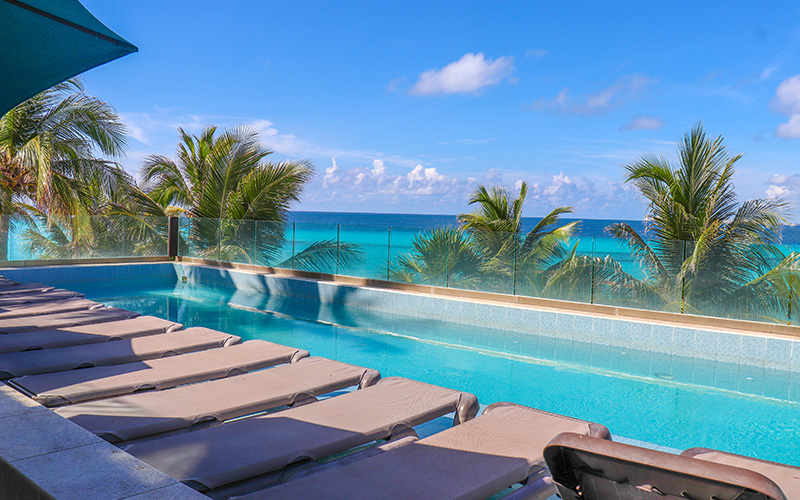 Panoramic image of Garrafon Park in Isla Mujeres showing hammocks and the sea in the background.