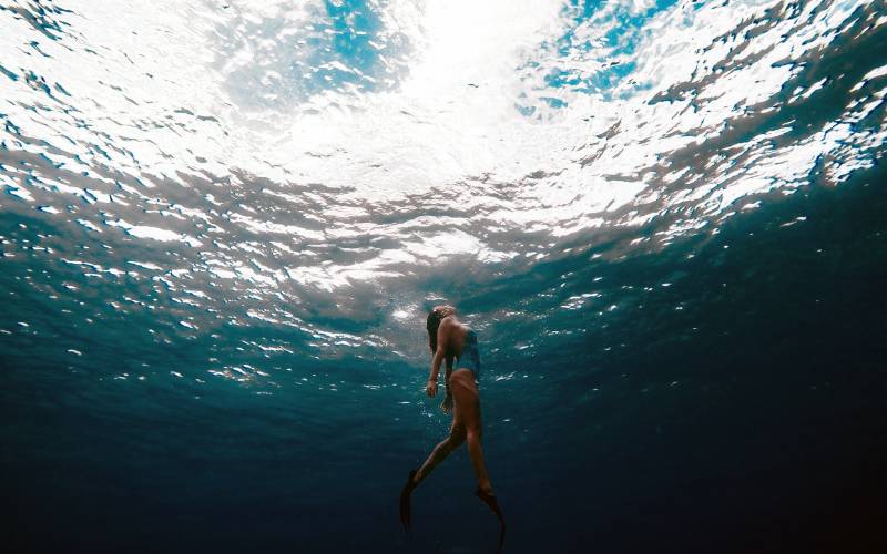 Mujer realizando snorkel en las aguas del mar caribe en Isla Mujeres