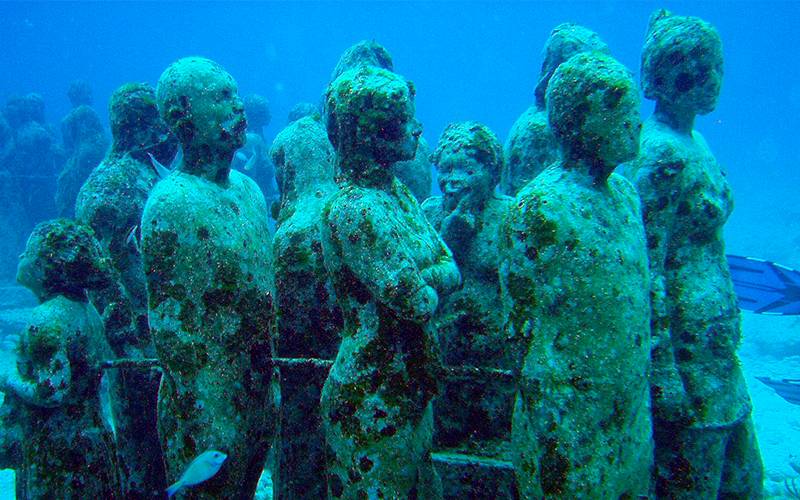 Esculturas de personas bajo el agua