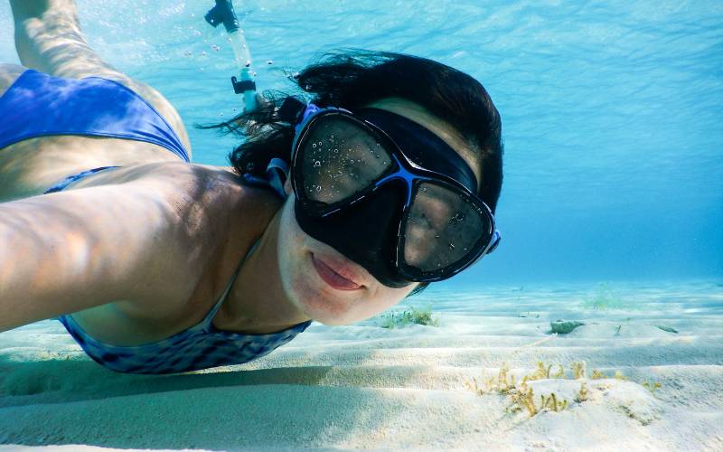 Mujer realizando snorkel en las aguas del mar caribe en Isla Mujeres