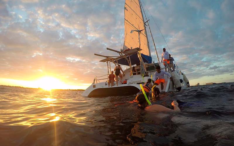 People sailing and diving in the crystalline waters of the Caribbean Sea near Isla Mujeres.